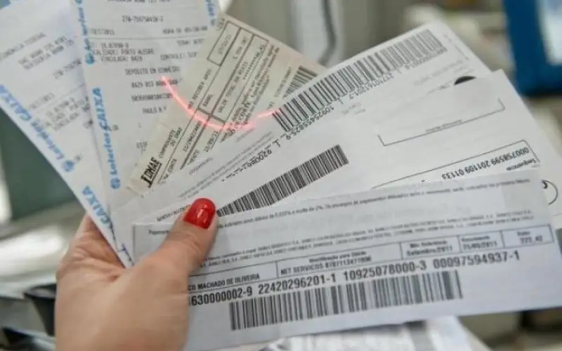 Close-up of a hand with red nail polish fanning several airline boarding passes and receipts with barcodes visible in the foreground.