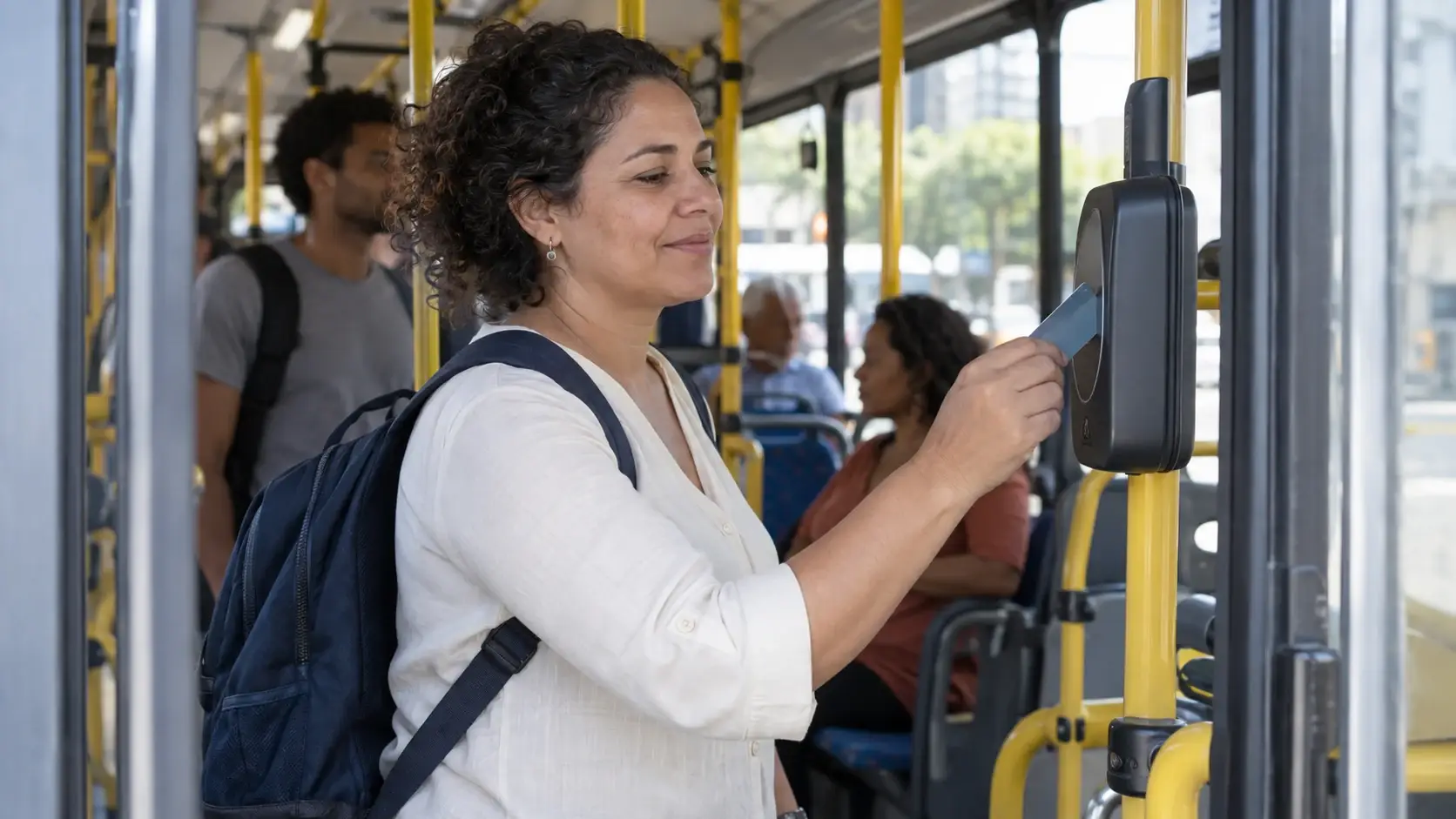 Trabalhadora aproxima um cartão do leitor ao embarcar em ônibus.
