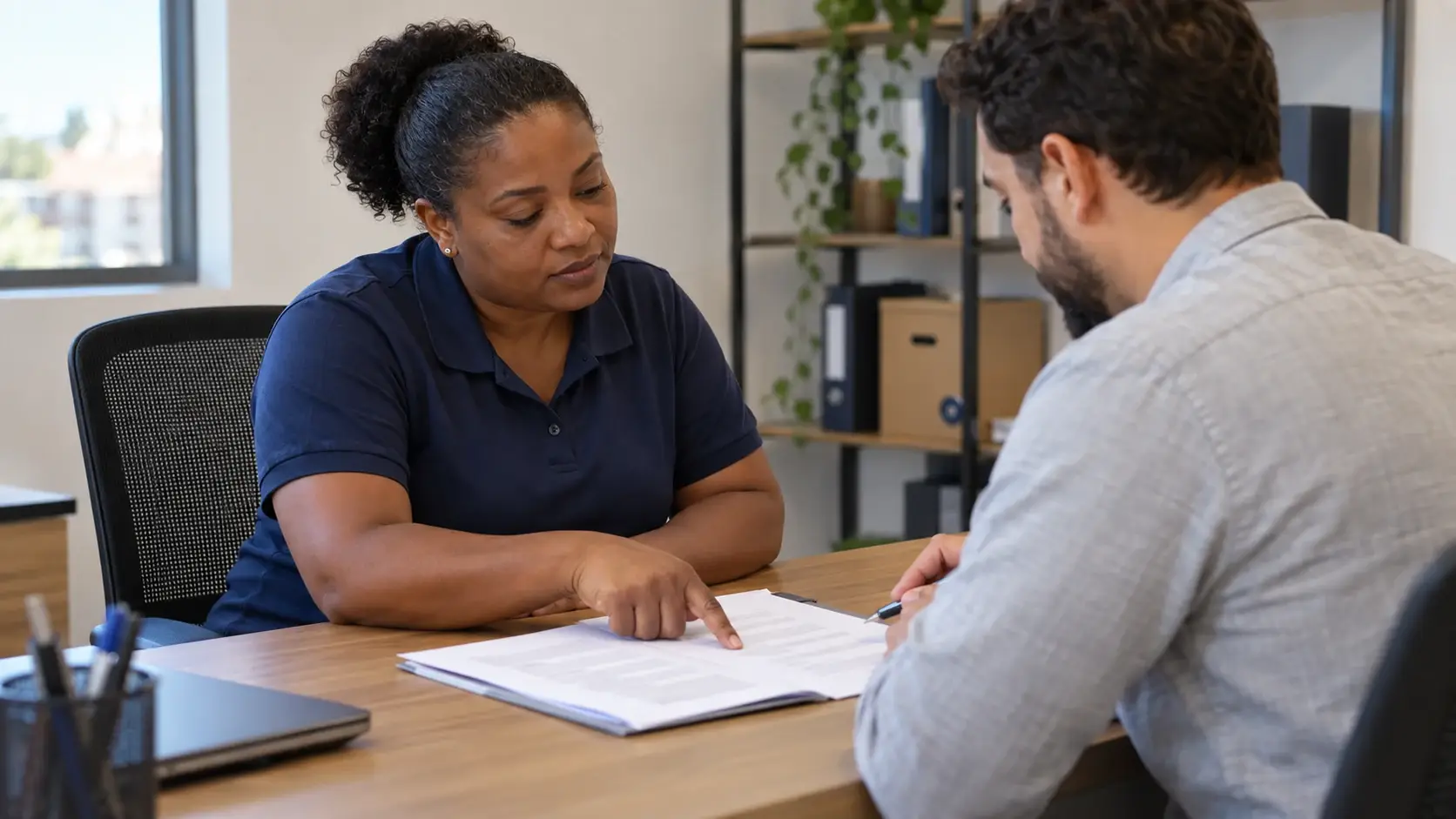 Trabalhadora conversa com um profissional de RH sobre documentos.