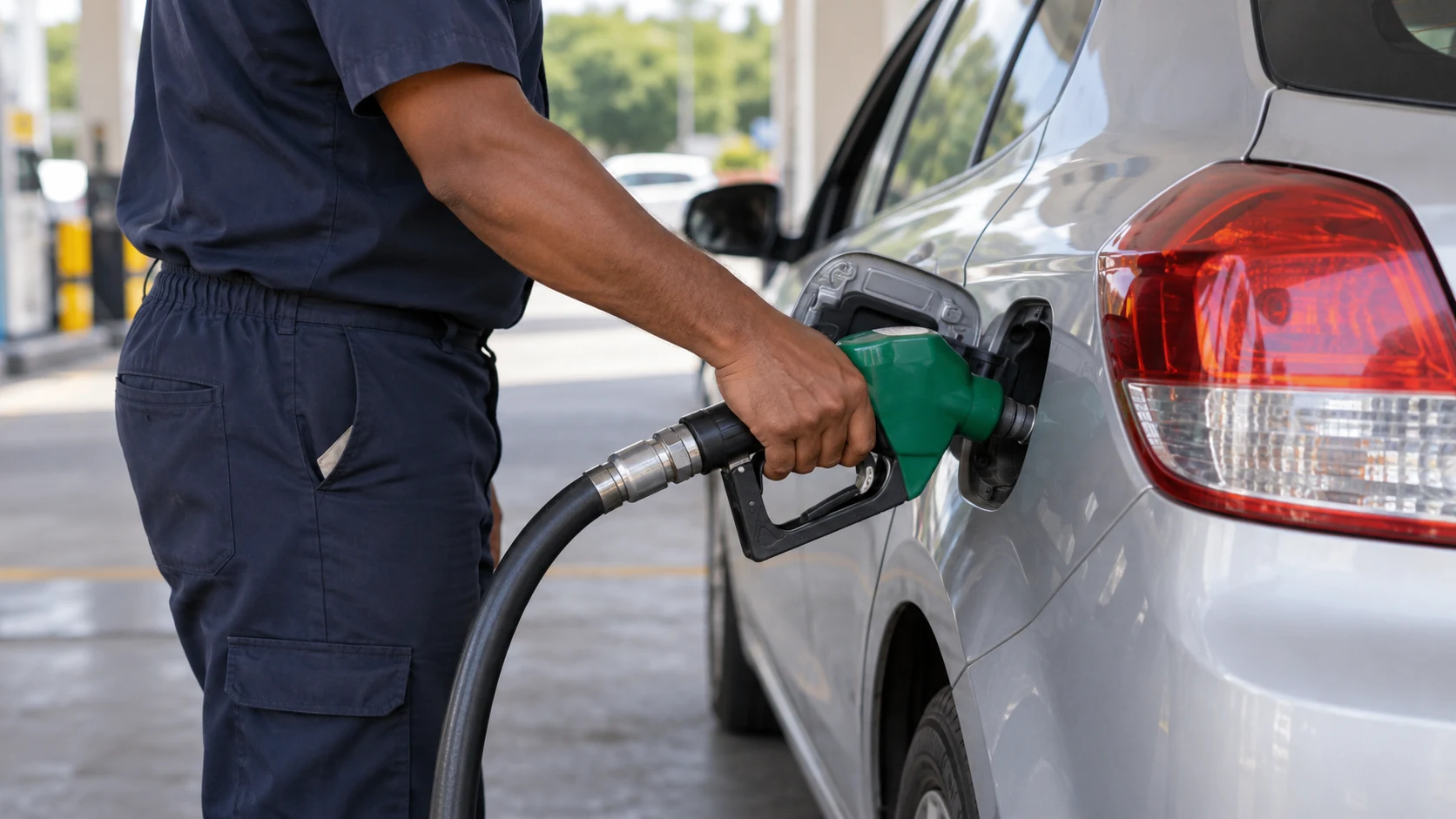 Frentista abastece um carro em um posto de combustíveis.