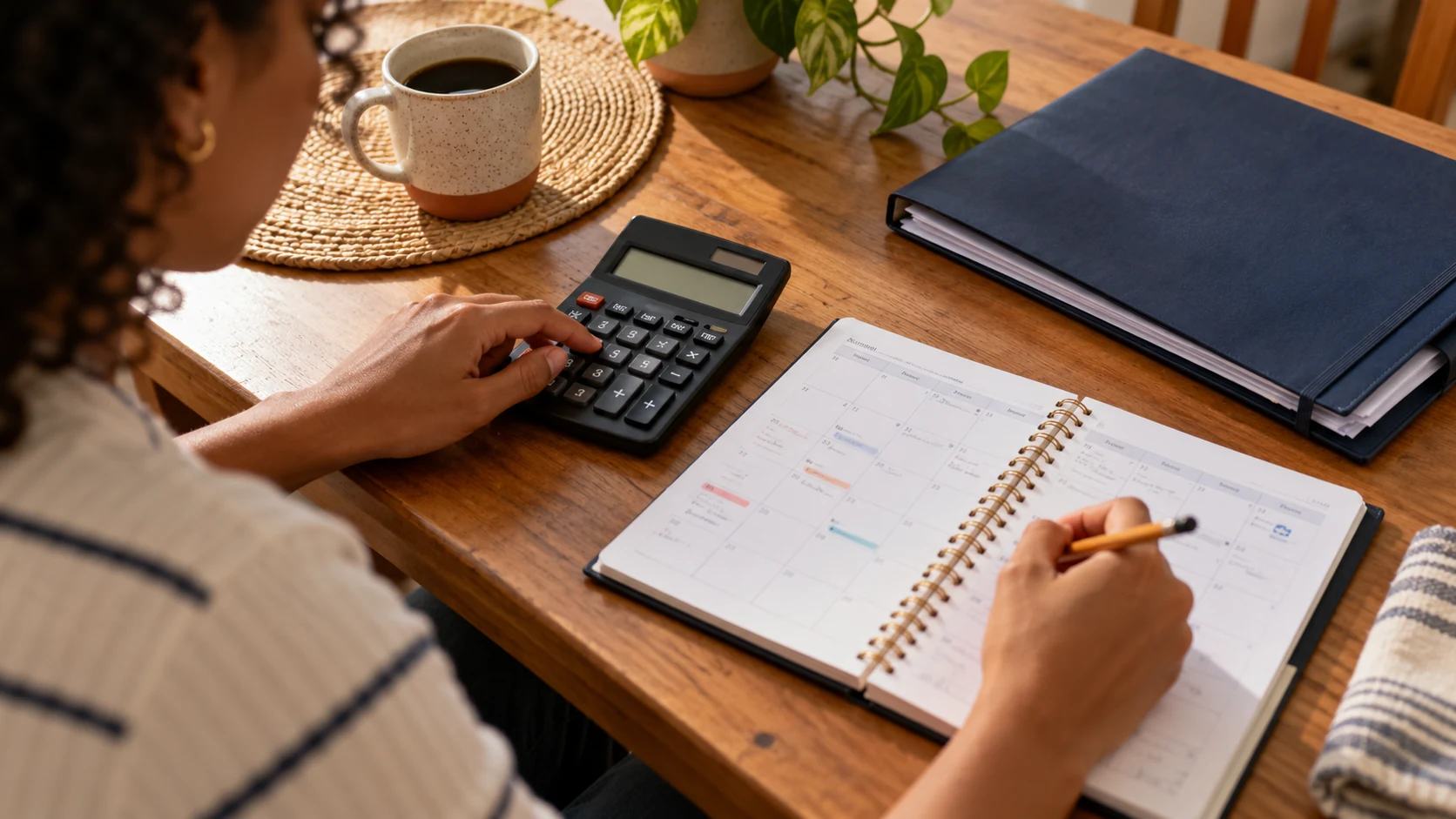 Calculadora, agenda e lápis usados para planejar o rendimento de uma aplicação.